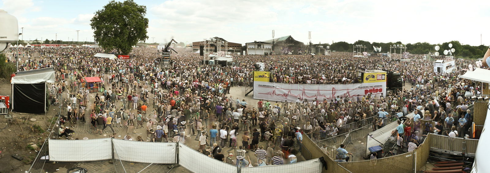 Blick auf die Loveparade 2010. Im Vordergrund Floats (Blick von Norden zur Hauptbühne, 24. Juli 2010, 17 Uhr)