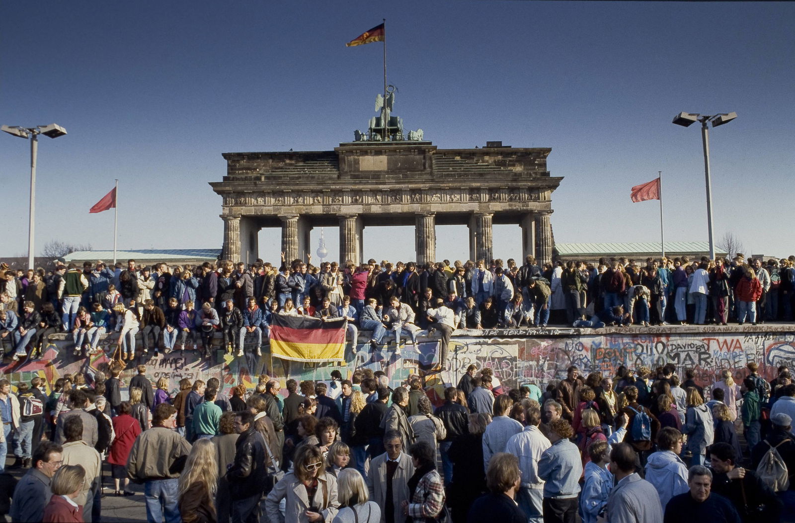 Menschen aus Ost und West feiern den Fall der Berliner Mauer am Brandenburger Tor in Berlin