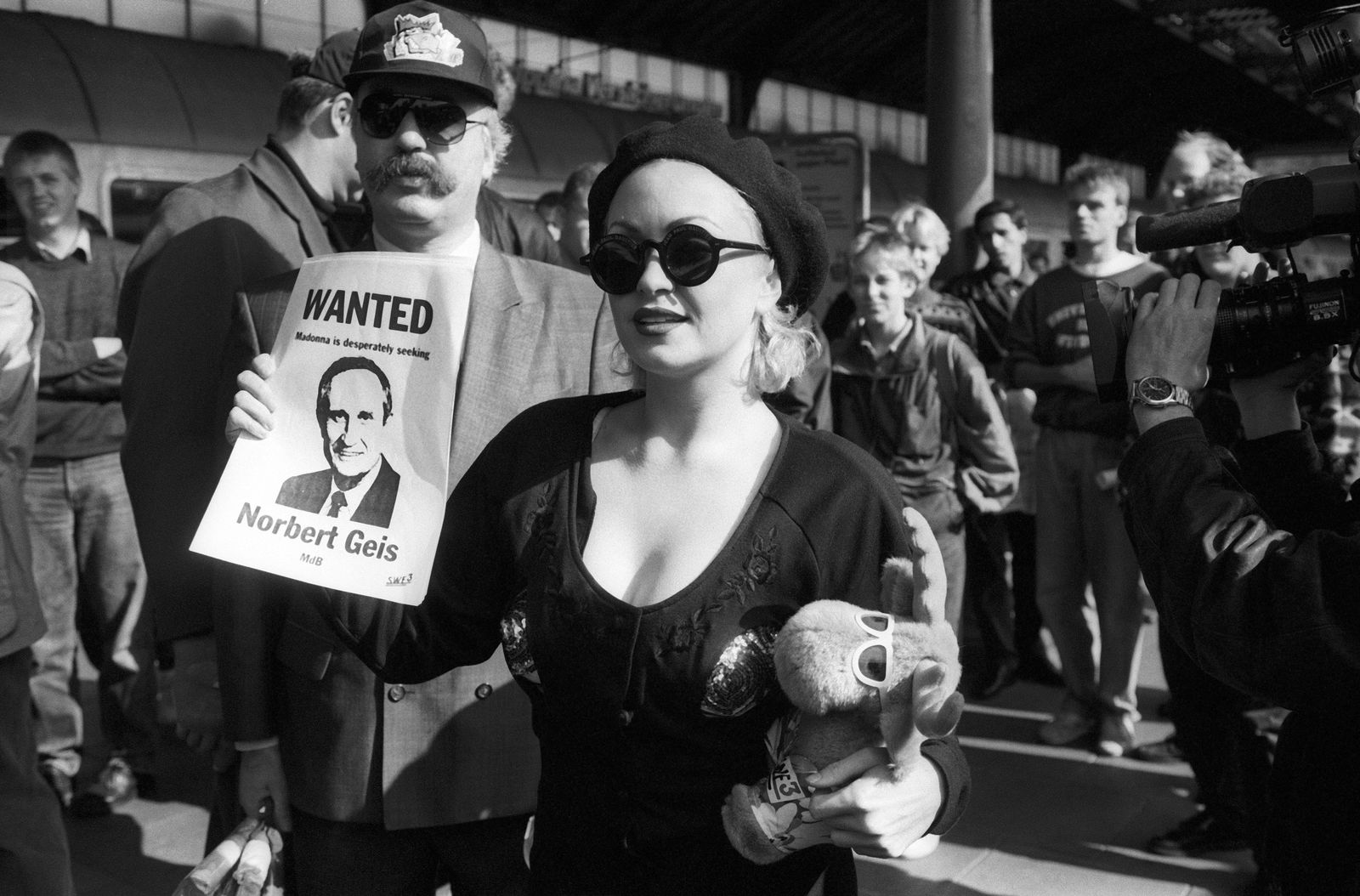 Madonna-Double mit einem Steckbrief von Bundestagsmitglied Norbert Geis auf einem Gleis des Bonner Hauptbahnhofs