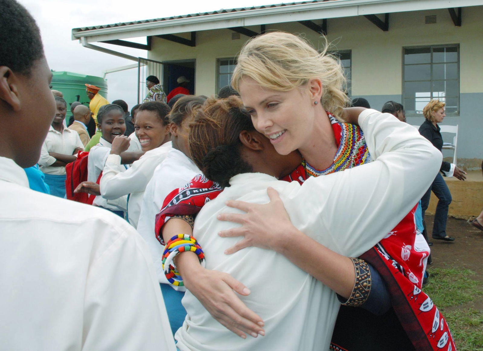 Südafrika. 2007: Charlize Theron begrüßt Schüler der Nhliziyo High School während der Vorstellung des Projekts „Mpilonhle Youth Education and Mobile Health”, das vom Charlize Theron Africa Outreach Project finanziert wird.